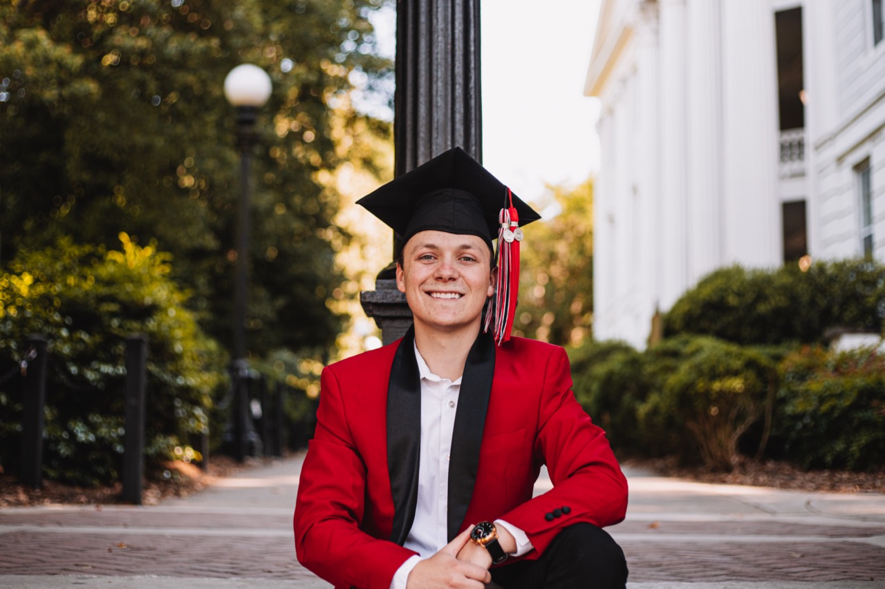 Bailey Pelletier in a red blazer with a graduation cap
